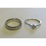 A platinum band ring marked 950 ring size J, weight 6g, together with a platinum solitaire ring,