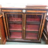 A Victorian lacquered display cabinet with inlay and two glass fronted doors, opening to reveal