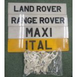 Four plastic signs one for Land Rover, another for Range Rover, another for Maxi, and another for