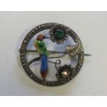 A sterling silver circular openwork brooch set with an enamelled exotic bird and stone set