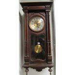 A Victorian style wall clock in case stained as mahogany. Westminster chime