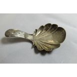 A silver caddy spoon with shell shaped bowl and patterned engraving throughout. Hallmarked for
