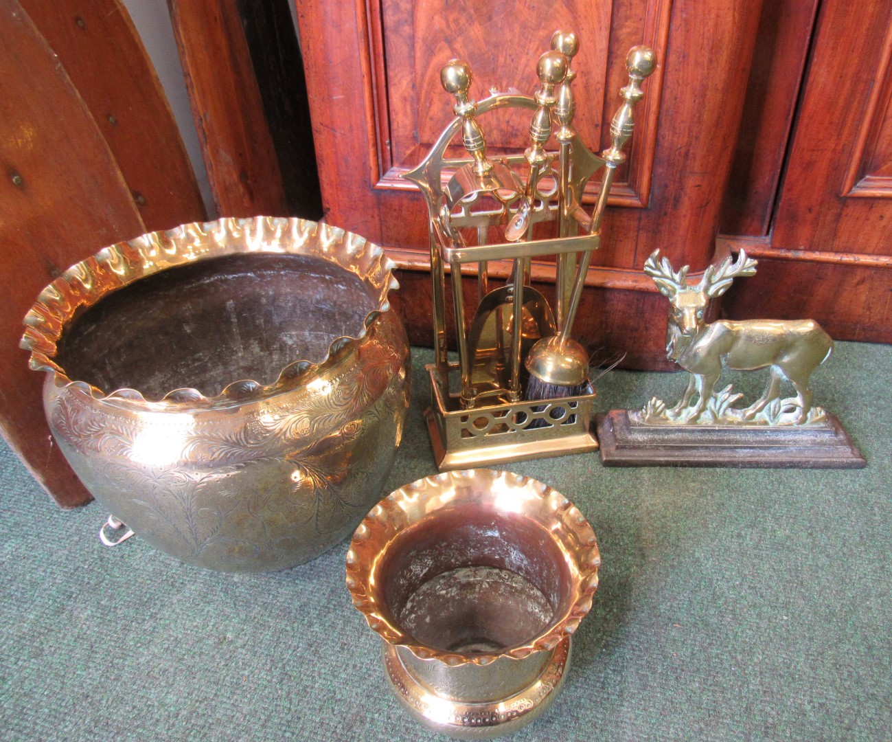 Quantity of brass including fire companion set, 2 brass planters and a nice old door stop in the