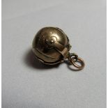 A gold/gilt masonic ball pendant that opens to a cross formation with masonic symbols. Faded marks