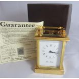 A boxed John Moreley carriage clock, gold plated brass finish, purchased in 1999 with guarantee.