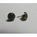 A pair of marked 375 gold jade stud earrings set with a circular cabochon of jade measuring 7.9mm in