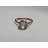 An unmarked rose gold/gilt white sapphire cocktail ring with the faceted round cut sapphire