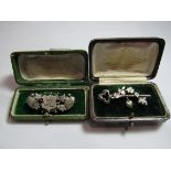 Two early 20th century silver brooches, one designed as a key with applied floral arch and a