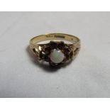 A marked 375 gold, opal and garnet flower head ring, size O, weight 2.1g.