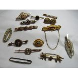 An early 20th century rose gilt metal bar brooch set with four tiny rose cut diamonds and a