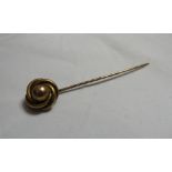 An unmarked gold (tested) ball and knot faced stick pin.