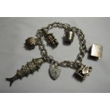 A silver and white metal charm bracelet to include an articulated fish and clown charms, gross