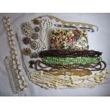 A large collection of costume jewellery to include long length shell necklaces and loose beads.