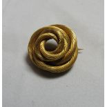 An unmarked gold, with testing indicating 18ct, finely worked carved knot brooch. Diameter 2.1cm,