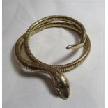 A 9ct gold snake bangle with internal steel spring, ruby paste eyes and engraved pattern to the