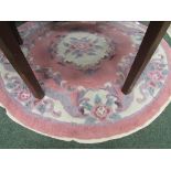 A predominantly rose pink and grey circular rug of oriental design, approx. 123cm diameter