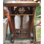 An oak lectern with carved decorative arched panel to back and with shelf