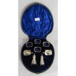WITHDRAWN An Edwardian silver cased set of condiments and salts including blue glass liners.