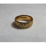 A Victorian 18ct gold floral embossed wide band ring, size N 1/2. Hallmarked Birmingham 1897, band