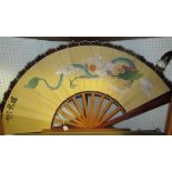 A large decorative fan with a five toed dragon decoration