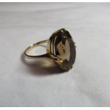 A marked 375 gold cocktail ring set with a large oval faceted smoky quartz stone measuring 18.7mm