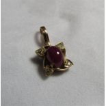 An unmarked Indian gold star ruby and diamond accent pendant piece with the oval cabochon ruby