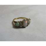 An 18ct gold, opal and diamond dress ring set with a central oval opal measuring approx. 8.5mm in