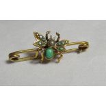 An unmarked gold (tested) insect brooch with the insect inset with a turquoise stone and coloured