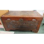 An oriental camphor chest with oriental ship carving in relief to front and top and with half size