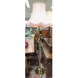 A modern brass lamp standard with pink shade