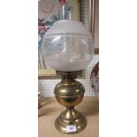 A Brass paraffin lamp with etched glass shade and clear funnel