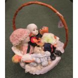 A wicker flower basket filled with an assortment of dolls and teddies