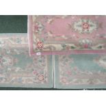 Three predominantly green and one pink oriental design rugs, each approx. 122cm x 60cm