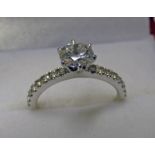 A SINGLE STONE DIAMOND SET RING WITH DIAMOND SET SHOULDER IN SETTING MARKED 750 OF APPROX 0.