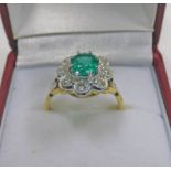 AN 18CT GOLD EMERALD AND DIAMOND CLUSTER RING, THE OVAL CUT EMERALD OF APPROX. 1.