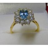 18CT GOLD AQUAMARINE AND DIAMOND SET RING. THE OCTAGONAL AQUAMARINE IN A SURROUND OF APPROX. 1.