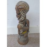 CARVED HARDWOOD TRIBAL AFRICAN FIGURE OF A MALE WEARING A BELLY MASK, WHITE PIGMENT TO BOTH FACES,