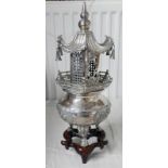 CHINESE WHITE METAL CANDLE HOLDER IN THE SHAPE OF A PAGODA WITH MARKS TO BASE ON HARDWOOD STAND