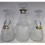 SILVER MOUNTED CUT GLASS DECANTER AND 2 CUT GLASS DECANTERS WITH SILVER BOTTLE LABELS