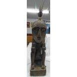 A LARGE EBONISED WOOD FIGURE OF A SEATED MAN WITH ANIMAL HAIR TOPKNOT,