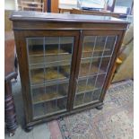 OAK BOOKCASE WITH LEADED GLASS PANEL DOORS