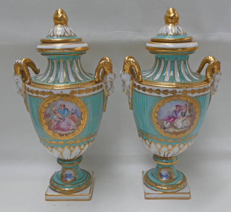 PAIR OF CONTINENTAL PORCELAIN PALE GREEN LIDDED VASES WITH TWIN GOATS MASK HANDLES ON SQUARE BASES