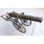 A DECORATIVE METAL CANNON WITH 28CM LONG BARREL MARKED 'GAAD' ON A METAL CARRIAGE WITH SPOKED METAL