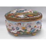19TH CENTURY NAPLES PORCELAIN OVAL CASKET DECORATED WITH RELIEF MOULDED CHERUB SCENE - 10 CM WIDE