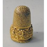 YELLOW METAL THIMBLE WITH BHUDDIST STYLE FIGURE DECORATION 8GMS