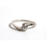 A platinum solitaire diamond ring, a round brilliant cut diamond in a claw setting, to pierced