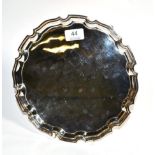 A shaped circular silver salver, C J Vander, Sheffiield 2006, plain on three scroll supports, 25.5cm