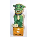 A Chinese heavily glazed temple lion on an integral plinth, late 19th century, 46cm height. Crazed
