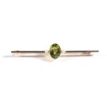 An Early Twentieth Century Peridot and Seed Pearl Brooch, an oval cut peridot in a claw setting,