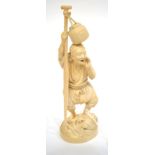 A Japanese Ivory Okimono, Meiji period, as a fisherman with a basket tied to an oar, on a wave